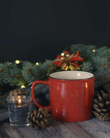 Cacao mug, christmas background with candles and pine cones on christmas tree branchの写真素材