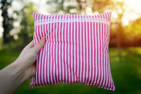 Pink striped pillow in hand closeupの写真素材
