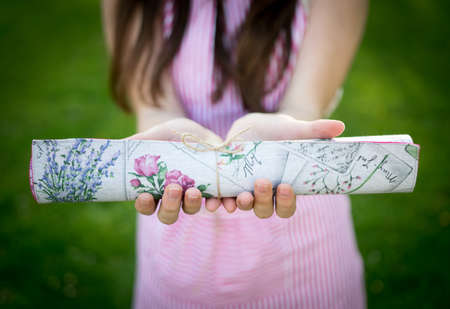 Young woman holding rolled table cloth closeupの写真素材
