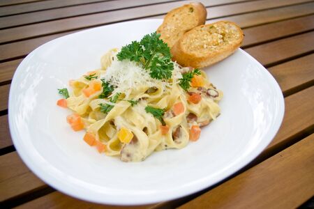 creamy pasta with cheese and crispy bacon top with grind cheese and parsleyの写真素材