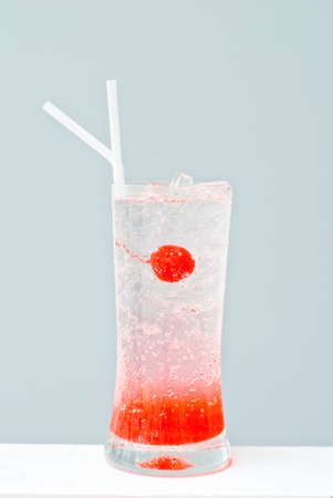 glass of cherry syrup and soda with cherry fruitの写真素材