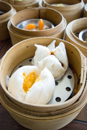 close up small custard and red roast pork stuffed salapoa in bamboo streamer with various dimsumの写真素材
