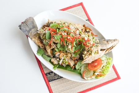 deep fried fish with spicy sauce and various herbsの写真素材