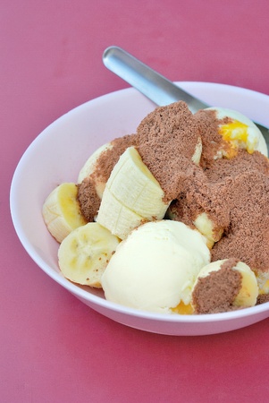 scoops of vanilla ice cream with banana topping with cocoa or chocolate powderの写真素材