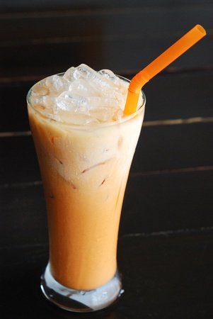 glass of Thai milk tea on black tableの写真素材