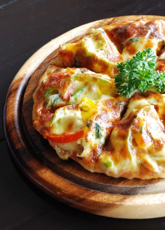 half shape of dilicious vegetarian cheezy pizza serves on wooden boardの写真素材