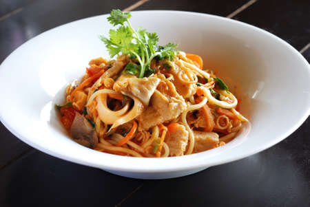spicy vegetarian spahetti in white plate on black tableの写真素材
