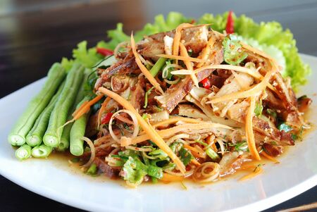 close up vegetarian hot and spicy salad and gluten imitated meat on white dishの写真素材