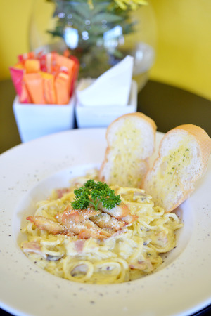 spaghetti carbonara with cream sauce and crispy chickenの写真素材