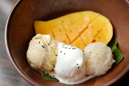 Selective focus of mango ice cream and vanilla ice cream with mango flesh and sticky rice