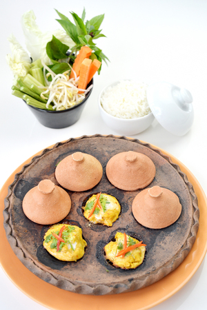 Selective focus of steam fish curry in stone pan on white background, Thai foodの写真素材