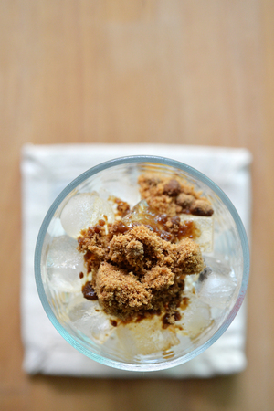 Selective focus of brown sugar heap on ice in glass.の写真素材
