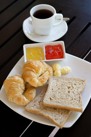 Croissant and bread with butter and jamの写真素材