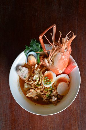 Selective focus of egg noodle with spicy soup and seafoodの写真素材