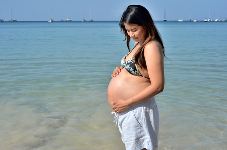 Young Asian pregnant woman relaxing on the seaの写真素材