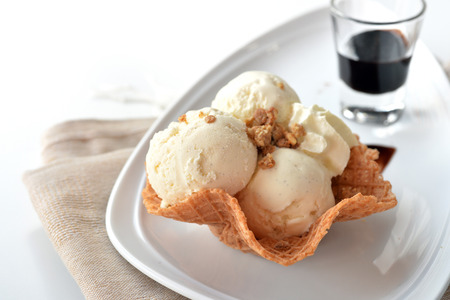 Selective focus of vanilla ice cream scoop with chocolate sauce on white backgroundの写真素材