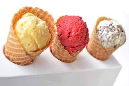 Selective focus on strawberry sorbet ice cream and other two ice cream on white backgroundの写真素材