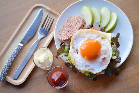 Selective focus of sandwich with fry egg, cereal bread, cheese and fresh vegetableの写真素材