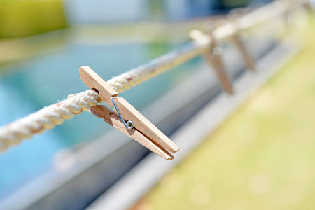 Wood clothespin hanging on rope outdoor, selective focusの写真素材