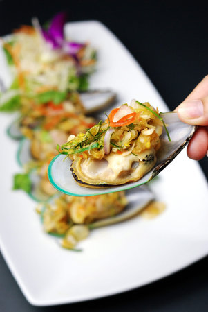Selective focus of steam sea mussel with hot and spicy chili sauce, Thai food