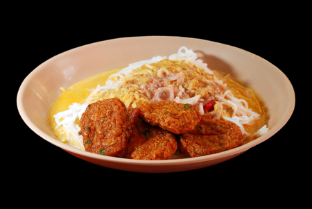 Isolated selective focus of Thai fish cake with rice noodle and curry on black background, Thod Mun Plaの写真素材