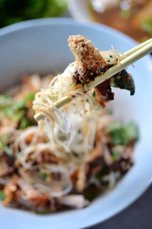 Using chopstick with Rice noodle and roast pork, selective focusの写真素材