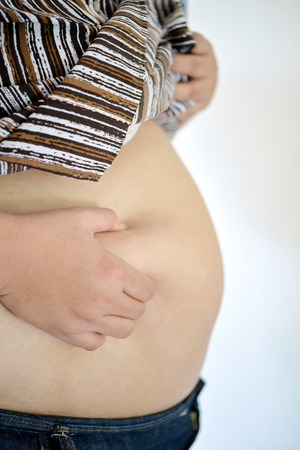 Woman fat belly touching by hand, close upの写真素材