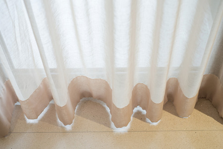 Classic light brown curtain hanging in roomの写真素材