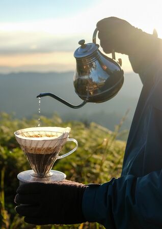 Man hand pouring filter coffee drip with outdoor natural backgroundの写真素材