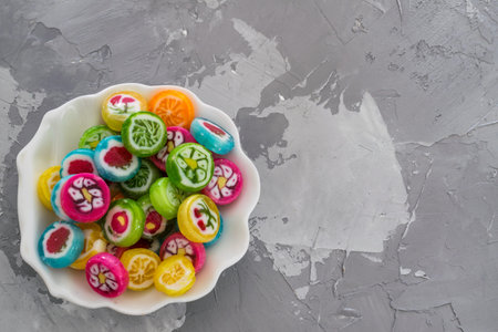 Colorful fruit candy sweets close up. different tastes and drawings of fruits on candies in boul...