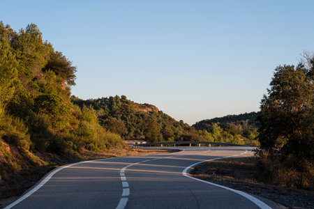 lonely mountain road with curves in autumnの写真素材