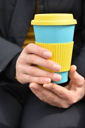 Close up girl's hand holding eco friendly coffee cup. Mug Conceptの写真素材