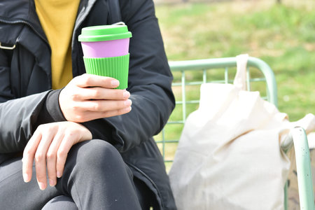 one girl sitting outdoors holding coffee cup on a city street background, take away coffee.Breakfast...