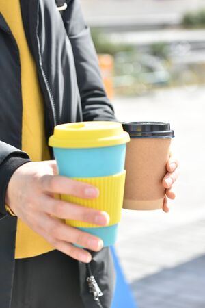 A female holding coffee cup mug in both hands, single use paper cupの写真素材