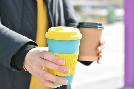 A female holding coffee cup mug in both hands, single use paper cupの写真素材