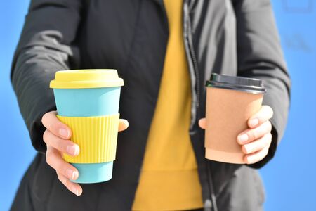 A female holding coffee cup mug in both hands, single use paper cupの写真素材
