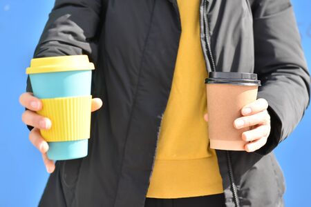 A female holding coffee cup mug in both hands, single use paper cupの写真素材