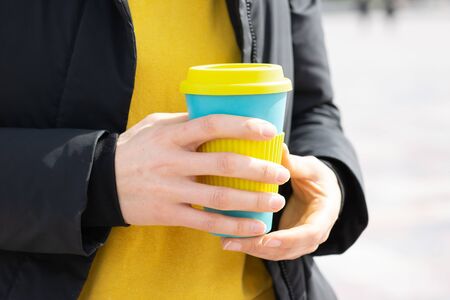 Female hands holding reusable coffee mug. Take your coffee to-go with reusable travel mug. Zero waste concept . Sustainable lifestyle concept. の写真素材