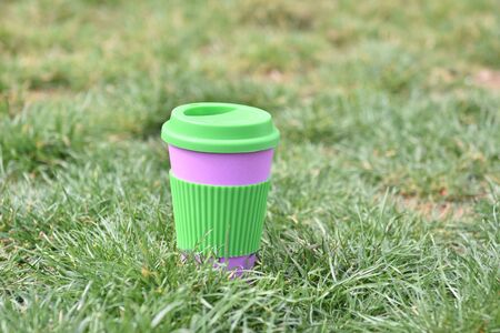 Reusable eco coffee cop on the green grass.Ban single use plasticの写真素材