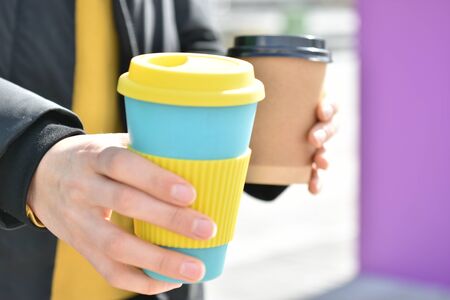 A female holding coffee cup mug in both hands, single use paper cupの写真素材