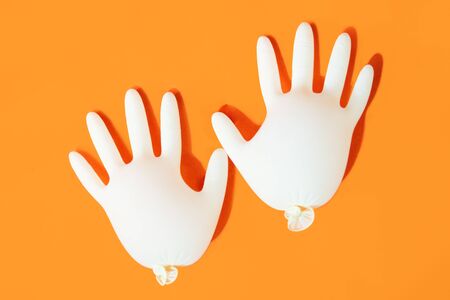 White medical gloves isolated on orange background. Protectionの写真素材