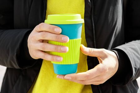 Female hands holding reusable coffee mug. Take your coffee to-go with reusable travel mug. Zero waste concept . Sustainable lifestyle concept. の写真素材