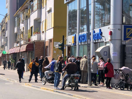 People waiting outside Credins Bank to withdraw money during Coronaのeditorial素材