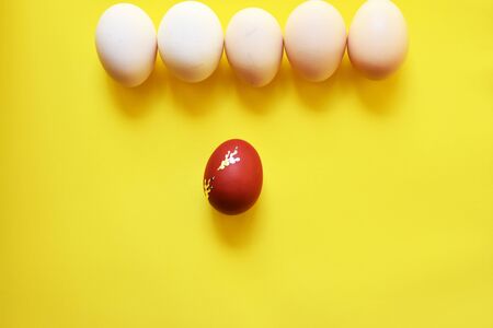 White Easter eggs on yellow minimalist background with one egg on red color.Easter Element.Top View,Flat lay,copy space.の写真素材