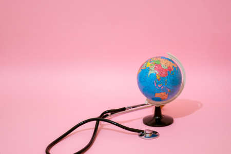 Earth globe with stethoscope on pastel background.のeditorial素材