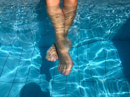 close up woman feet in swimming pool.summer holiday concept.の写真素材