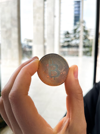 Female holding in her hand symbol of crypto currency .