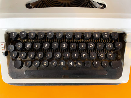 Typewriter machine in retro style on yellow background. Top view.