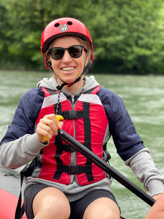 Women wearing sun glasses ready for rafting with her safety helmet .