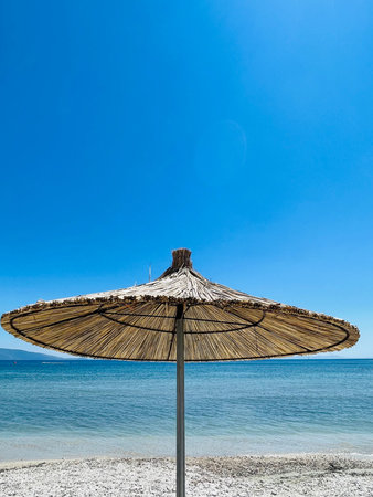 Straw beach umbrellas on a blue sky and sea background.Copy spaceの写真素材